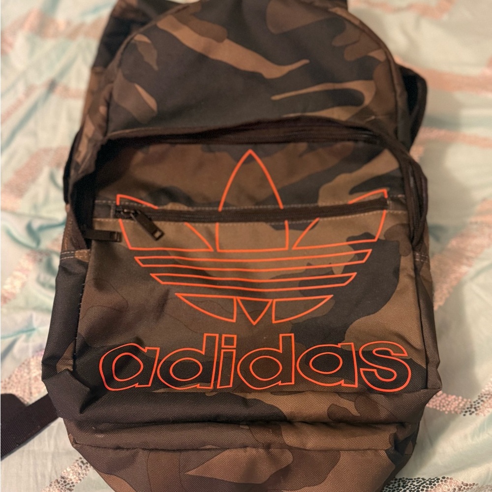 Adidas Brown, Green and Black Camouflage Backpack with bright orange logo.